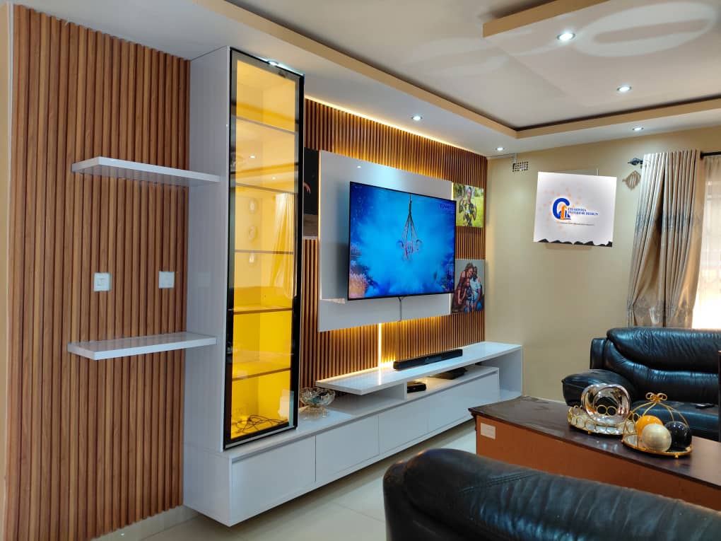 Timber slat TV wall with floating white console, amber glass cabinet and warm LED backlighting